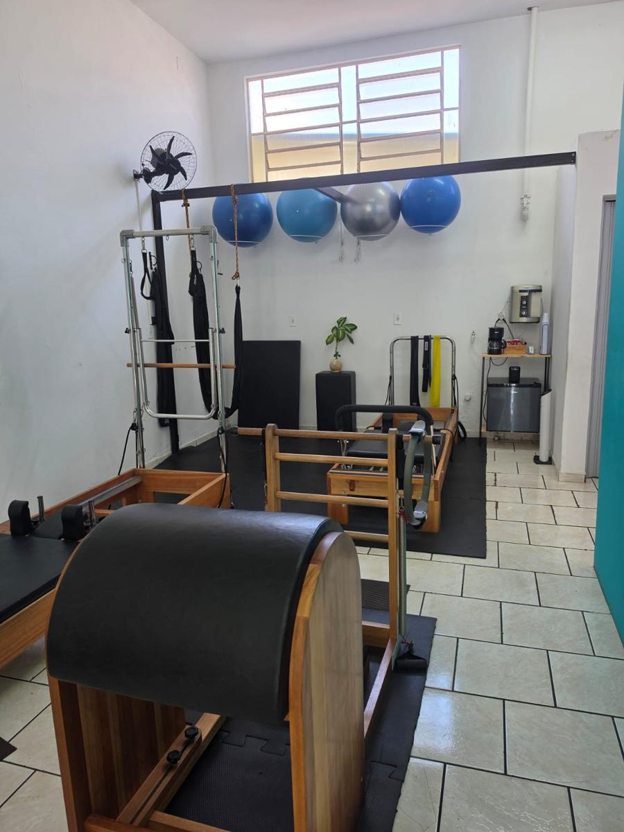 Sala de Pilates com Cadillac, Reformer e Chair, parede verde-água e bolas suíças